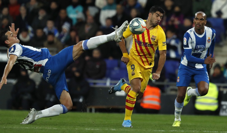 Bernardo Espinosa del Espanyol despeja el balón ante el acecho de Luis Suárez del Barcelona. AP