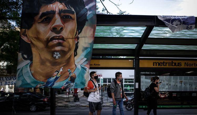 Carteles y banderas alusivas al exfutbolista y entrenador argentino Diego Armando Maradona cuelgan en una estación de bus cercana a la clínica Olivos.  Foto:EFE