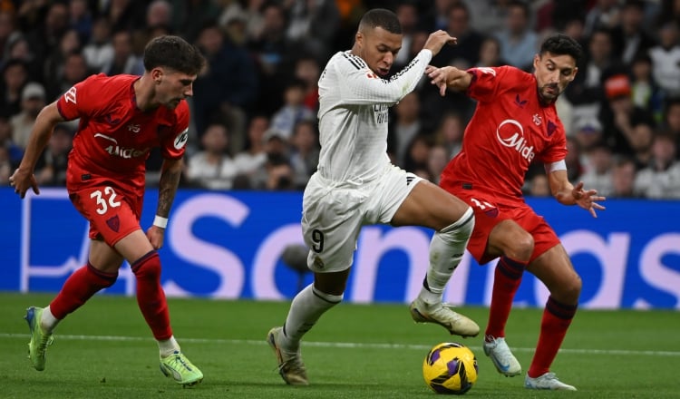 Kylian Mbappé (9) conduce el balón ante la marca de un jugador del Sevilla. Foto: EFE