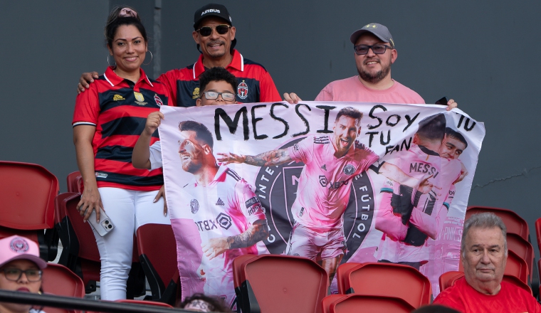 Aficionados sostienen un cartel de Lionel Messi. Foto:EFE