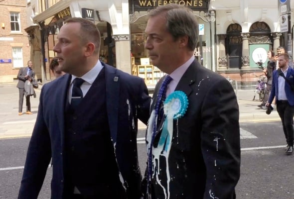 Nigel Farage, de Gran Bretaña, después de ser golpeado con un batido durante una caminata de campaña en Newcastle, Inglaterra. FOTO/AP