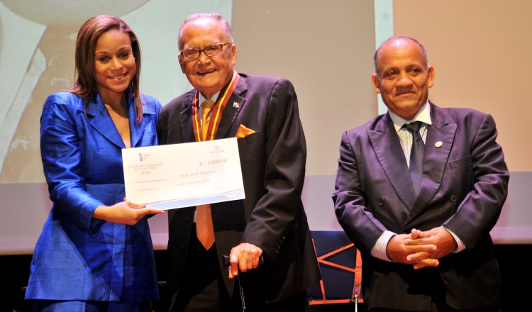 Janelle Davidson, directora general del Instituto nacional de cultura entrega a José Franco el cheque que acompaña la Medalla. Jaime Codero.