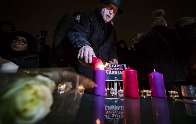 Un grupo de personas ponen velas en la Plaza parisina de la República. FOTO/AP