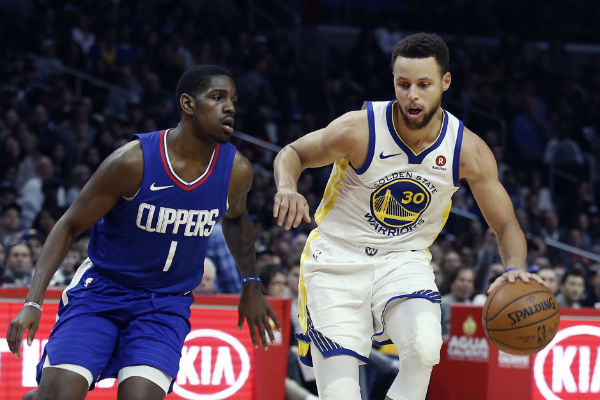 Stephen Curry (der.) de los Warriors es marcado por Jawun Evans de los Clippers. Foto:AP