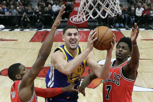 Klay Thompson  de los Warriors (cent.) anota una canasta ante el acecho de Kris Dunn (32) y Justin Holiday de los Bulls. Foto:AP