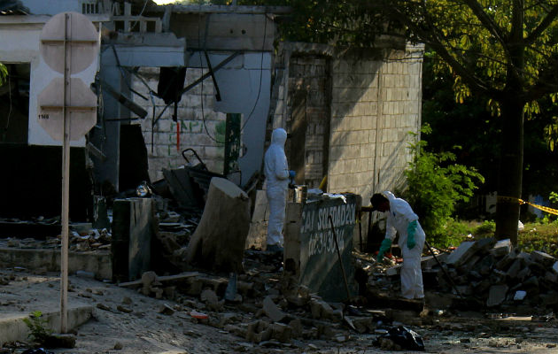 Investigadores de la policía revisan el lugar donde explotó un artefacto. FOTO/EFE 