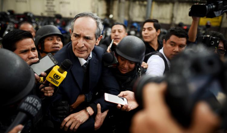 El expresidente de Guatemala Álvaro Colom (c-i) camina escoltado tras ser capturado. EFE