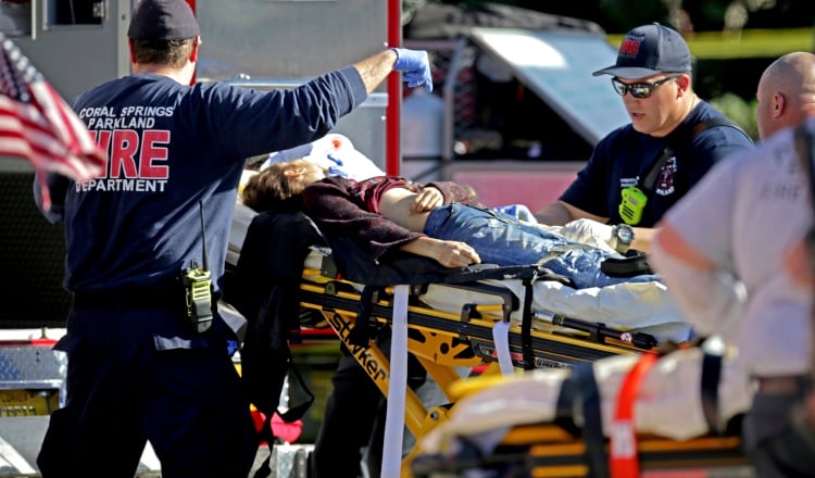 Paramédicos le brindan ayuda a los heridos en el colegio Marjory Stoneman Douglas High School. AP