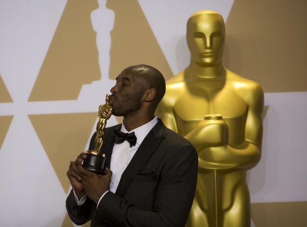 Kobe Bryant con su estatua de los Oscar. Foto AP