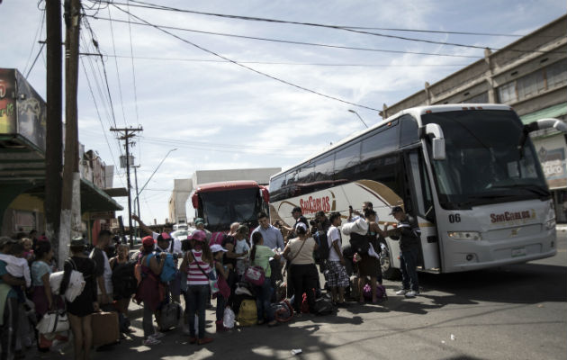 Miembros de la caravana de migrantes viajan en autobuses. FOTO/AP