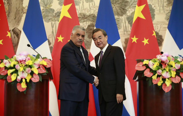El ministro dominicano de Relaciones Exteriores, Miguel Vargas (i), y su homólogo chino, Wang Yi, se dan la mano después de una ceremonia de firma donde formalmente establecieron relaciones diplomática