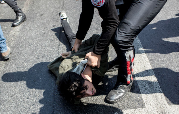 Agentes antidisturbios pone bajo custodia a uno de los manifestantes. FOTO/EFE