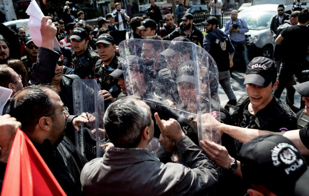 Manifestantes turcos se encaran a los agentes antidisturbios mientras tratan de proseguir su marcha.FOTO/EFE