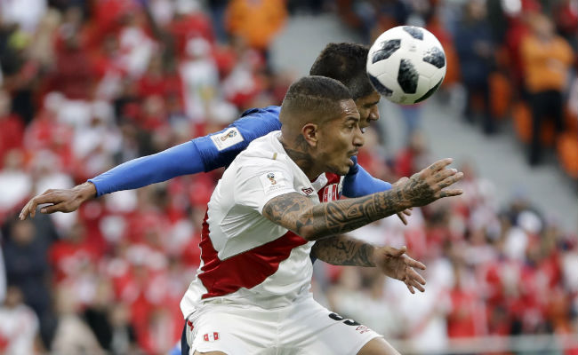 Paolo Guerrero de Perú (der.) salta a remtar el balón ante el francés Raphael Varane. Foto:AP