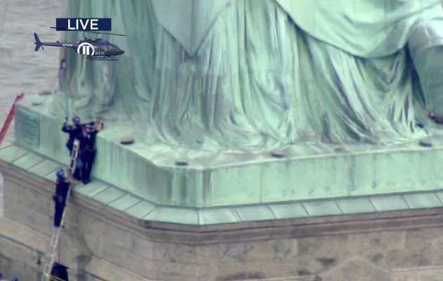 La policía trata de bajar de la Estatua de la Libertad. FOTO/AP