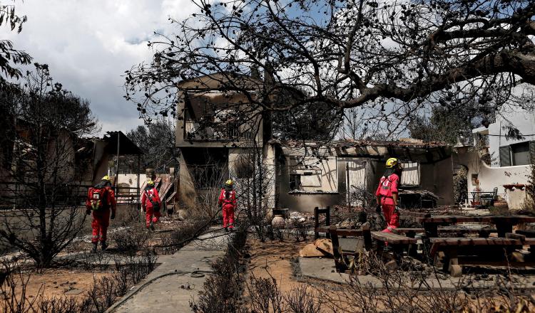 Miembros de la Cruz Roja buscan personas desaparecidastras el incendio en Grecia. EFE