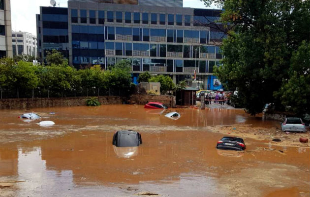 Coches cubiertos de agua en una calle de Atenas. 