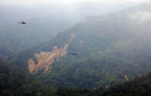 Un helicóptero de las operaciones de rescate sobrevuela la zona donde un helicóptero se estrelló. Foto: EFE  