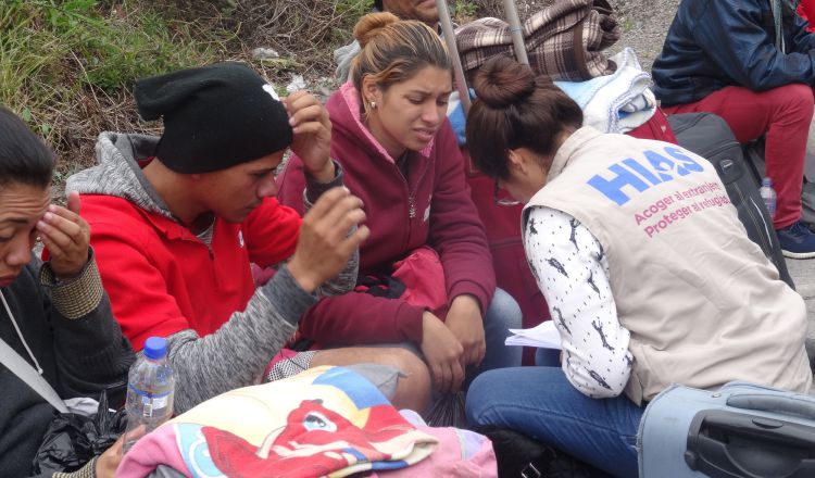 Inmigrantes venezolanos hablan con personal de una organización de ayuda al refugiado en Tulcán (Ecuador). EFE