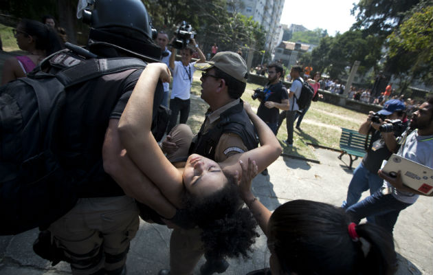 Una estudiante se deja llevar por atención médica después de desmayarse frente al Museo Nacional. Foto: AP