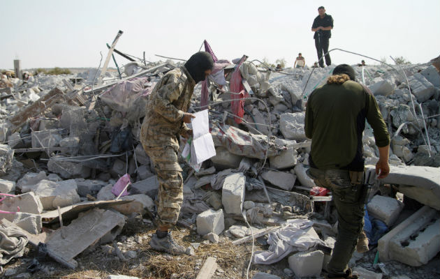 Personas sobre el edificio destruido en Barisha, Siria, donde murió el líder del Estado Islámico. Foto: EFE.