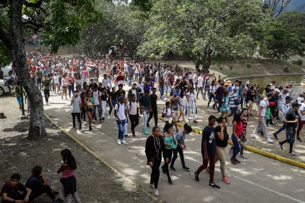 Personas cruzan una laguna tras salir de un concierto en las instalaciones del Parque Generalisimo Francisco de Miranda este sábado en Caracas. FOTO/EFE