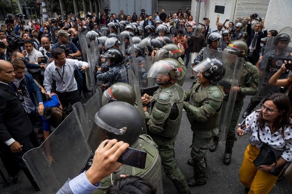 Opositores venezolanos lucha contra la Policía para poder ingresar a la Asamblea Nacional. FOTO/EFE