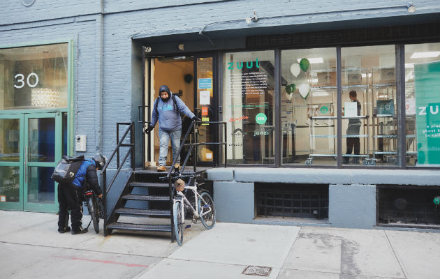 Encargados del reparto de comida entran y salen de un local en Manhattan que maneja seis restaurantes. Foto / Andrew White para The New York Times.