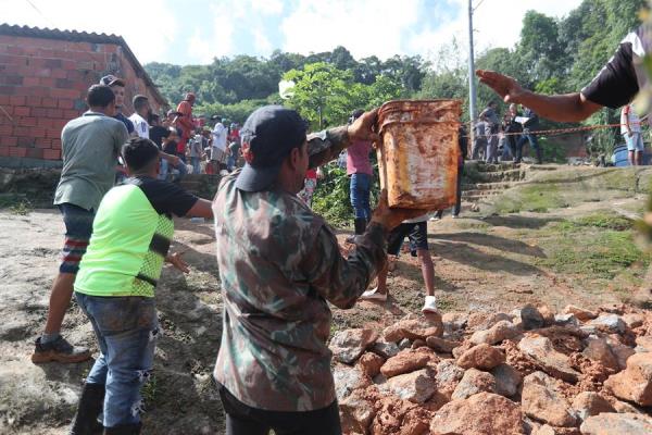 habitantes y bomberos buscando a los desaparecidos tras el derrumbe en el 