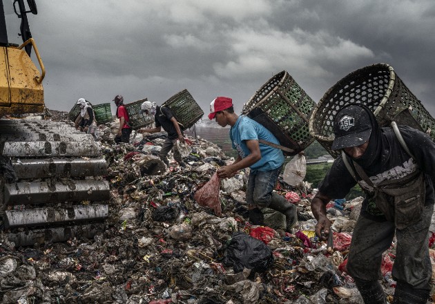 Recicladores y niños desde los 5 años buscan basura reutilizable junto a máquinas grandes y peligrosas. Foto / Adam Dean para The New York Times.