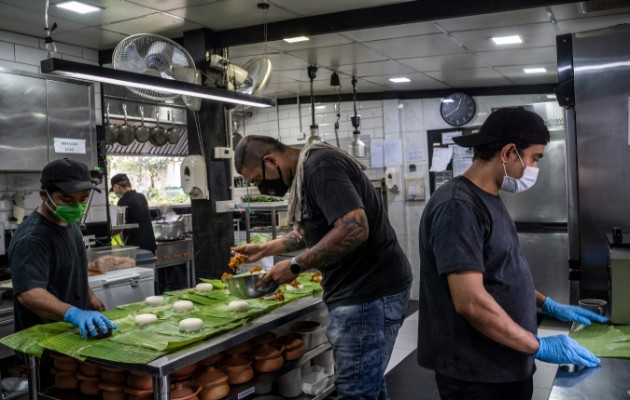  El chef del restaurante de alta cocina Haoma preparando comidas con cocineros que son migrantes birmanos para entregarlas a los migrantes afectados por el brote de coronavirus, en Bangkok. (Adam Dean / The New York Times)