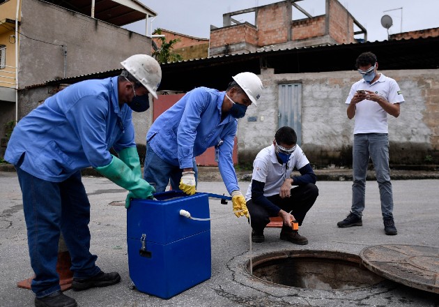 Científicos confían en que buscar el coronavirus en el drenaje ayude a predecir futuros brotes. Investigadores en Brasil recolectan muestras. Foto / Douglas Magno/Agence France-Presse — Getty Images.