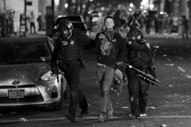 Un manifestante es detenido por la policía, luego de participar en una protesta contra el racismo y abuso policial en Portland, Oregon, Estados Unidos, este domingo 26. Foto: EFE.