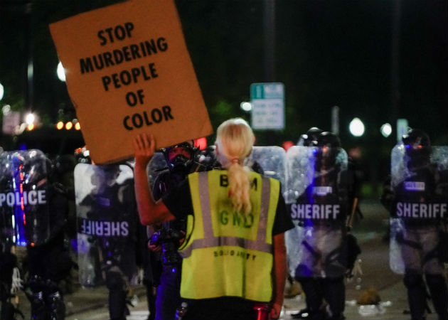 Una manifestante confronta a la Policía en Kenosha (EE.UU.), en la continuación de las protestas por el ataque policial contra Jacob Blake. Fotos. EFE.