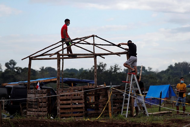 Un hombre construye una casa improvisada en el terreno 