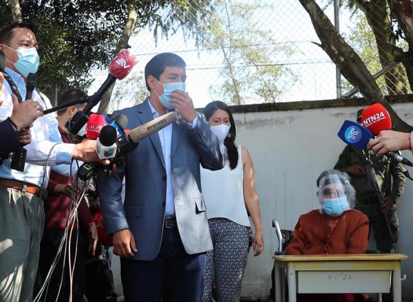 El candidato Andrés Arauz habla con la prensa mientras acompaña a su abuela Flor Cervina Galarza, de 106 años, a votar hoy, en Quito (Ecuador).