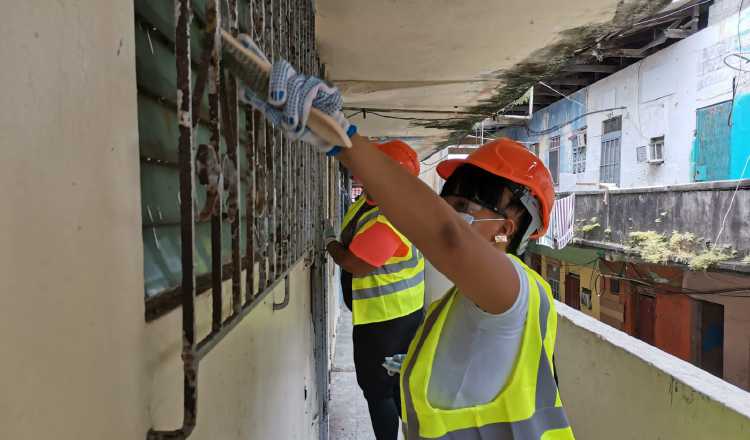 La mujer colonense está participando de la primera parte de la revitalización de los edificios, que consiste en raspar verjas y puertas de hierro para luego pintarlas.