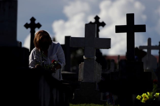 Una mujer deposita flores en el Cementerio de Amador durante el Día de los Difuntos en ciudad de Panamá. Foto: EFE