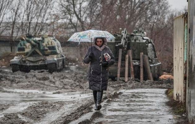 Una mujer camina cerca de vehículos armados en la estación de tren de la región de Rostov, Rusia. EFE