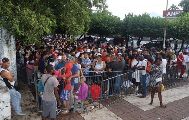 Migrantes hacen fila mientras esperan para regularizar su documentación en el municipio de Tapachula. Foto: EFE