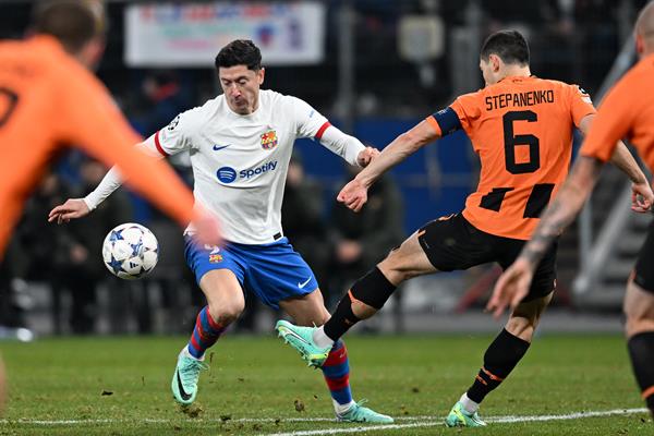 Robert Lewandowski del Barcelona (blanco) en acción contra Taras Stepanenko de Shakhtar Donetsk's (6) en la Champions. EFE