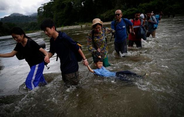 Migrantes cruzan el río Turquesa en Darién. Foto: EFE