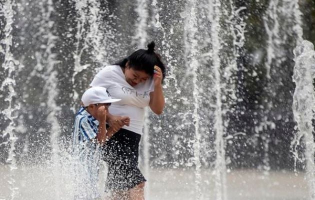 Personas se refrescan en la fuente de la explanada del Monumento a la Revolución en la Ciudad de México. Foto: EFE