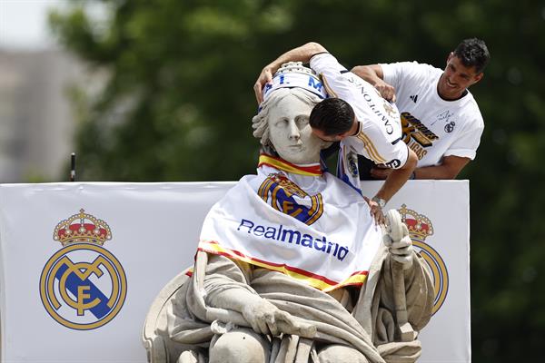 Nacho Fernández coloca la bufanda a la estatuta de la diosa Cibeles en Madrid. Foto: EFE