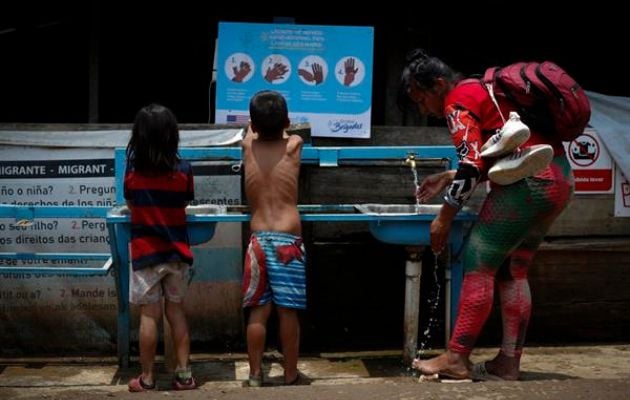 Una mujer y dos niños migrantes tras cruzar la selva del Darién. Foto: EFE