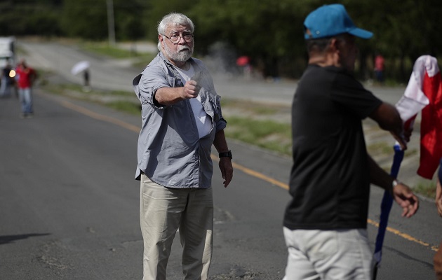 Fotografía de archivo fechada el 7 de noviembre de 2023 que muestra a un hombre mientras dispara un arma hacia un manifestante en medio de un bloqueo de docentes en la vía Panamericana. Foto: EFE/Bienvenido Velasco