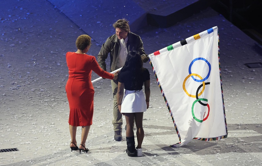 La alcaldesa de Los Angeles, Karen Bass (i), y la gimnasta Simone Biles, entregan la bandera olímpica actor estadounidense Tom Cruise. Foto: EFE