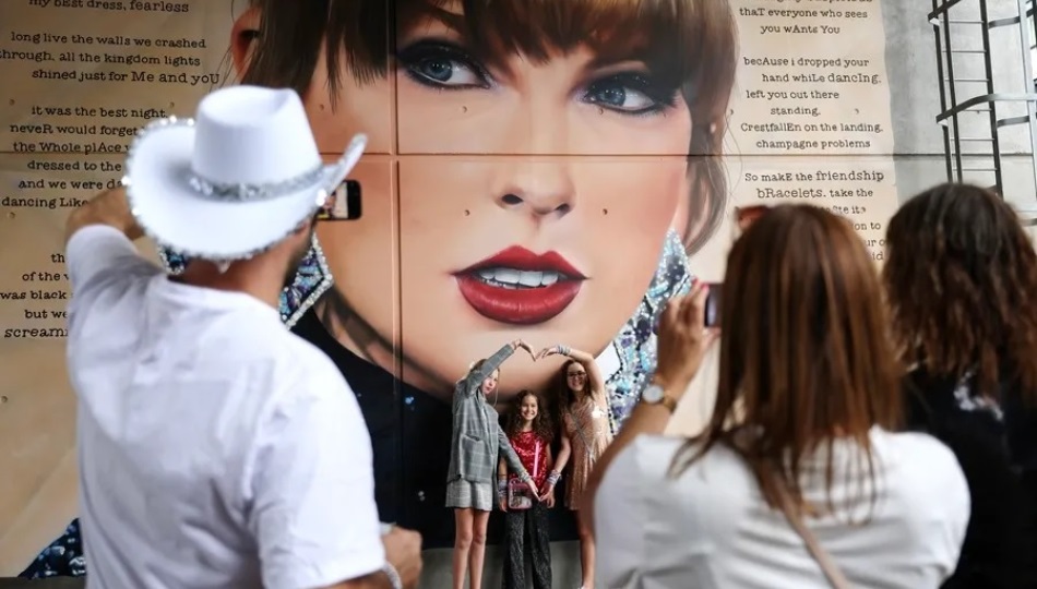 Fans de Taylor Swift observan un mural de la cantante estadounidense. Foto: EFE / EPA / Andy Rain