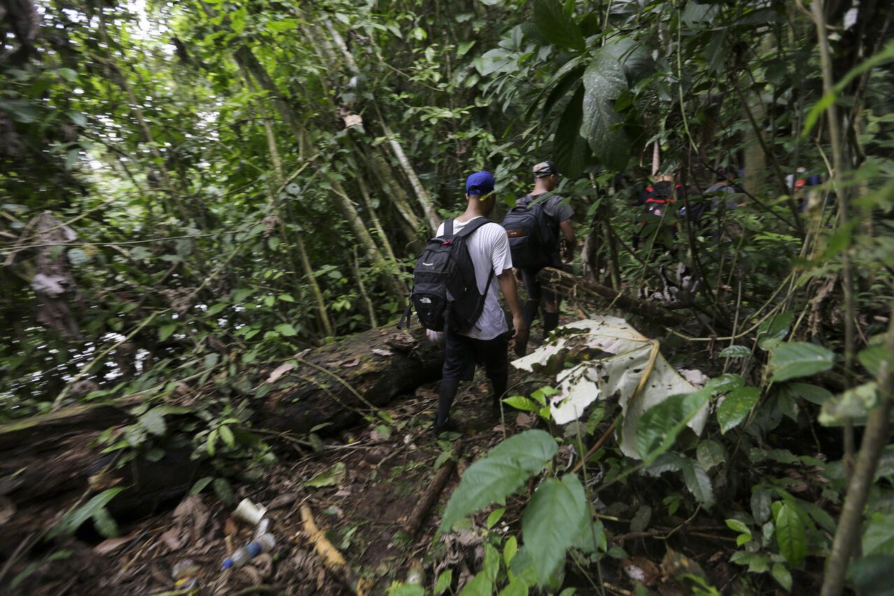   Migrantes de diferentes nacionalidades cruzan un campamento en plena selva del Darién, frontera natural entre Colombia y Panamá. Foto/Carlos Lemos/EFE