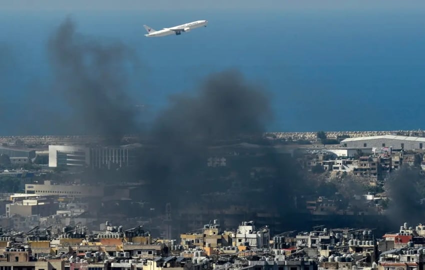 Un avión vuela mientras se eleva una columna de humo en Beirut, Líbano, el 5 de octubre de 2024. EFE/EPA/WAEL HAMZEH